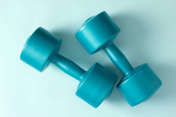 istock Blue vinyl dumbbells on a blue background. Close-up. Top view 1371873126