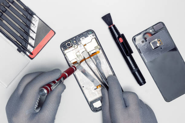 istock Technician repairing inside of mobile phone on the grey surface. the concept of computer hardware, mobile phone, electronic, repairing, upgrade. 1371873189