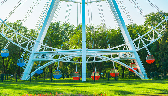 Amusement ferris wheel in the park. grass background.