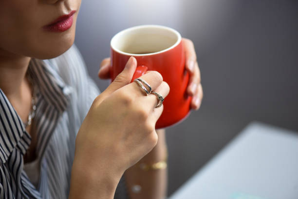 Woman drinking a beverage and wearing a hat