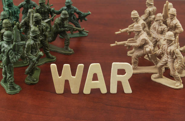 Two groups of toy soldiers attack each other with word WAR. War and military conflict concept. Two groups of toy soldiers attack each other with word WAR. special forces vietnam stock pictures, royalty-free photos & images