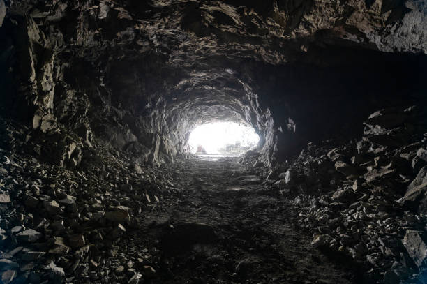 Underground mining, tunnel in the rock. There is a bright light at the end of the tunnel stock photo
