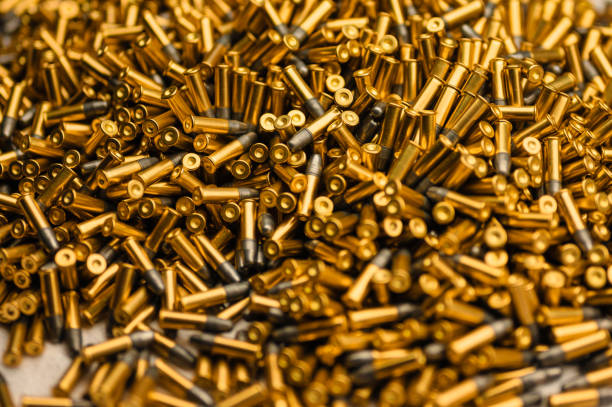 istock Small-caliber bullets on white table at production plant 1371881496