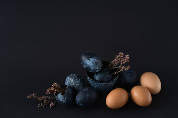 istock composition of nine Easter eggs and dried flowers on black dark background, Easter still life in dark key 1371886661