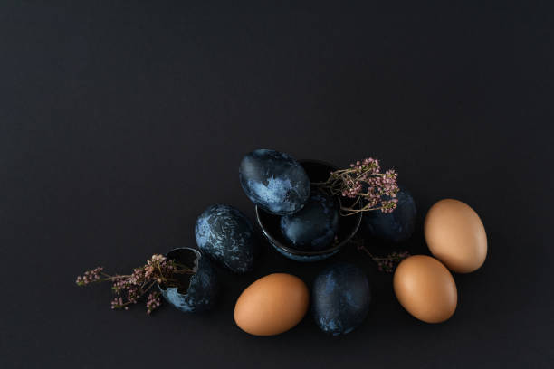 istock composition of nine Easter eggs and dried flowers on black dark background, Easter still life in dark key 1371886664