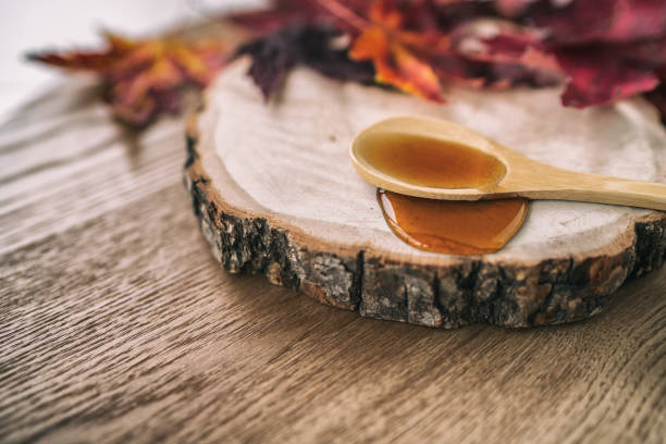 istock Maple syrup sugar liquid in wooden spoon from Quebec restaurant sugar shack called Cabane a sucre maple trees sap farm. Canadian delicacy sweet dessert ingredient 1371887504