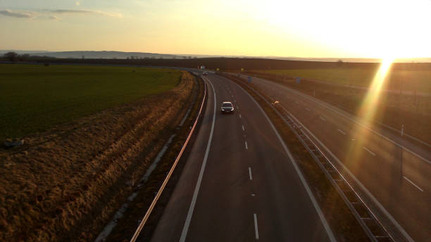 istock A car on a road under beaming sunset 1371888873