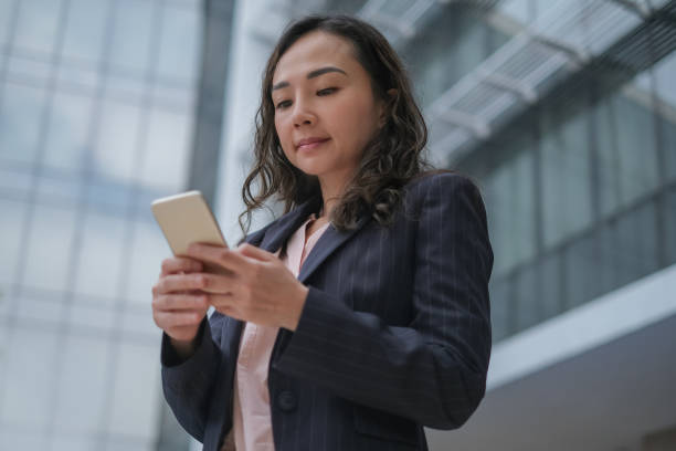 istock Asian Business Woman Replying Client Messages From Mobile Phone 1371888890