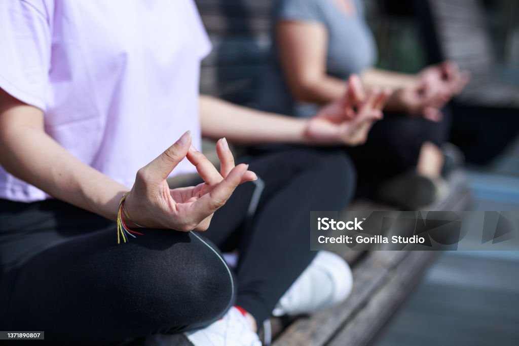 Close up of womens hand doing meditation Close up of women hand and finger doing meditation on bench at the outdoor park in the morning 20-24 Years Stock Photo