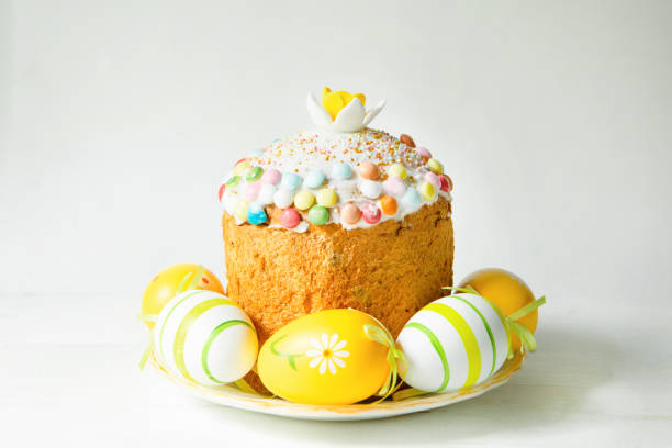 easter cake with painted eggs on a platter in a gray interior. traditional festive food - paastaart stockfoto's en -beelden