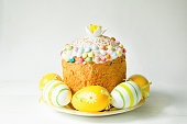 Easter cake with painted eggs on a platter in a gray interior. Traditional festive food