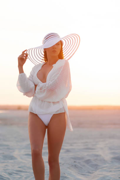 istock Seductive woman in beachwear on sunset shore 1371893884