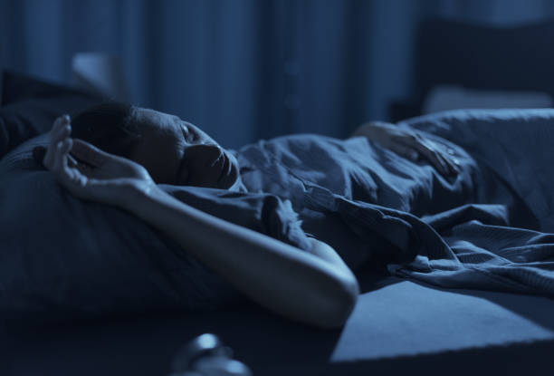 istock Woman sleeping in her bed at night 1371893915