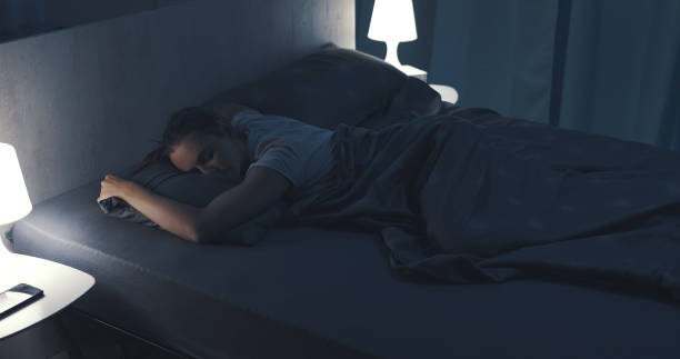 istock Woman sleeping in her bed at night 1371893950