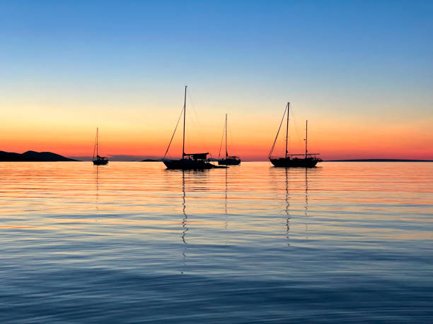 Sailboat moving in Adriatic sea against orange sky during the sunset
