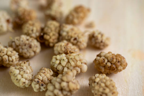 istock dried mulberry fruit. isolated on wooden surface. 1371896412