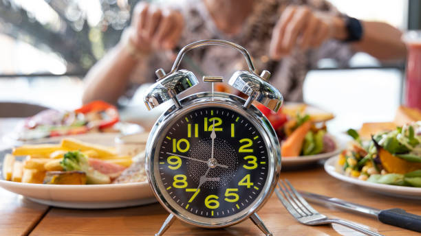 Selective focus of Alarm clock with young man eating a healthy food as Intermittent fasting, time-restricted eating-Diet breakfast image Selective focus of Alarm clock with young man eating a healthy food as Intermittent fasting, time-restricted eating-Diet breakfast image 1234 stock pictures, royalty-free photos & images