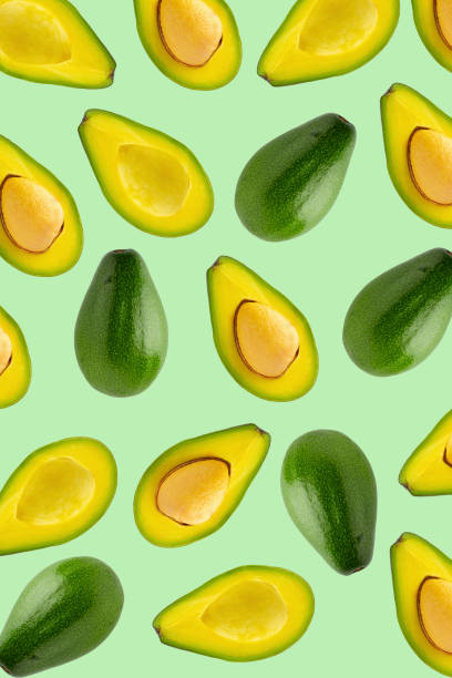 istock Slices and half of avocado isolated over a green background. 1371898155