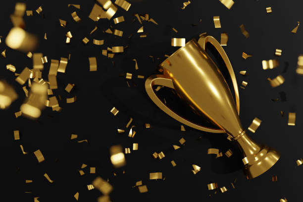 istock Winners golden cup and confetti isolated on black background 1371899054