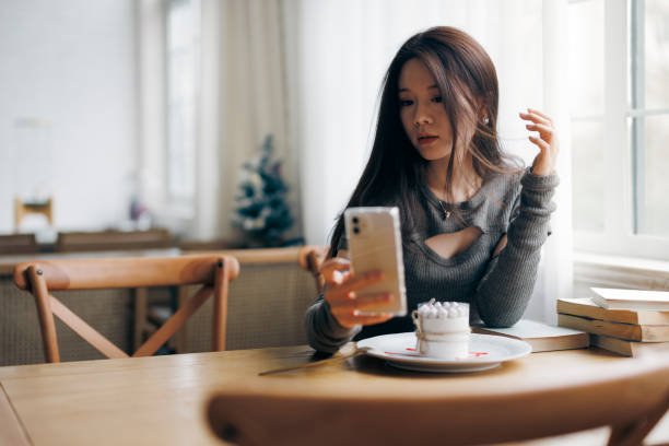 istock Young woman taking selfie with mobile phone in cafe 1371900669