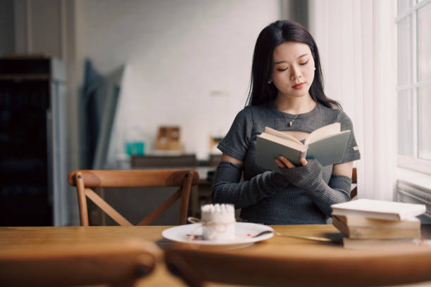 istock young Asian woman reading a book in a cafe 1371900724