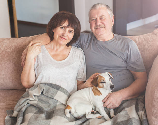 istock Happy elderly couple sitting on sofa at home 1371900922