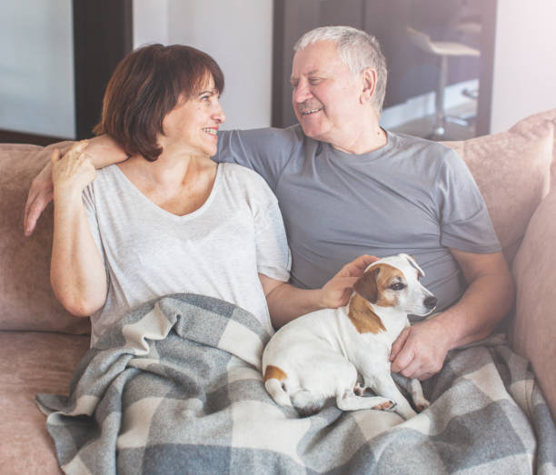 istock Happy elderly couple sitting on sofa at home 1371900924