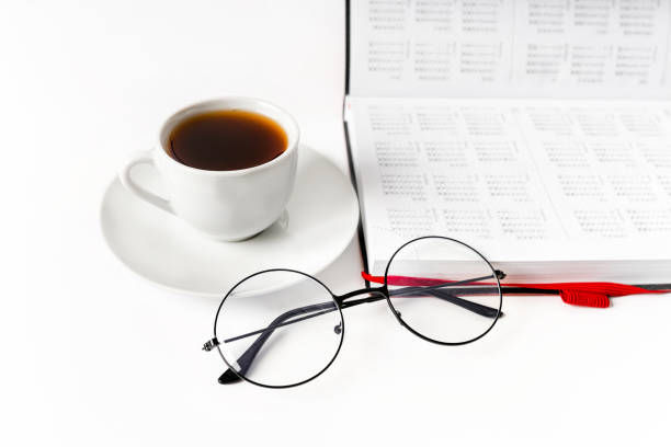 A modern office desk with a notepad, glasses and a coffee or tea cup on a white background with a place for text