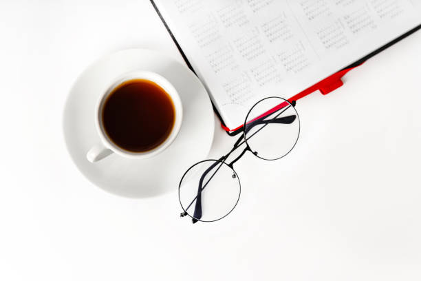 istock A modern office desk with a notepad, glasses and a coffee or tea cup on a white background with a place for text 1371901005