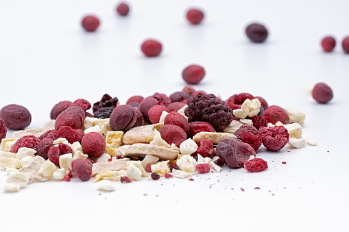 a heap of freeze dried berries and banana on white background