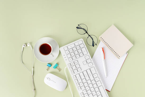 istock Light green office desk, minimalist style desk with keyboard, tea mug and glasses, copy space, top view, flat layout, layout 1371901812
