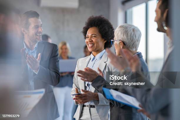 Happy Business Colleagues Applauding In A Hallway Full Of People Stock Photo - Download Image Now
