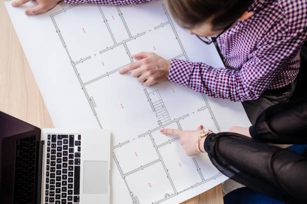 istock Architecture team working on a project and pointing finger to print project of a house. 1371904993