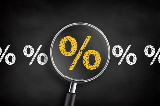 Searching for Interest Rate. Percentage sign with magnifying glass on chalkboard stock photo