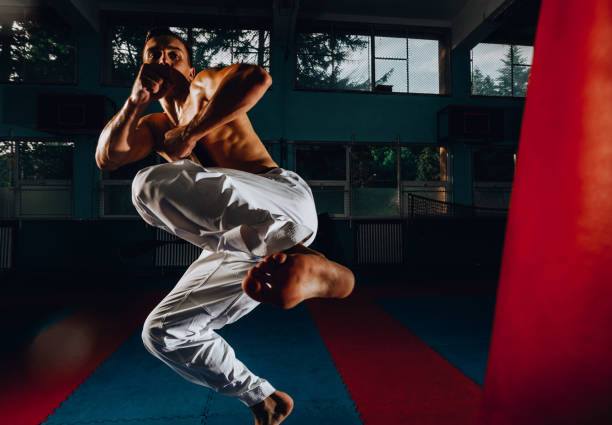 istock Man hitting the punching bag on black background 1371905799