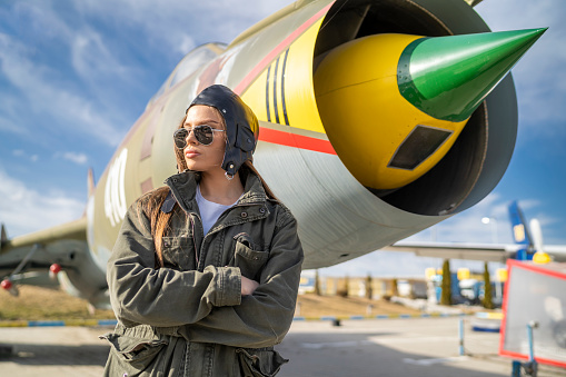 Army woman standing behind plane , preparing for flying