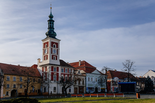 Old Town Hall with Clock Tower at the main Masaryk square of historic medieval royal town Slany, colorful renaissance houses in sunny winter day, Central Bohemia, Czech Republic, December 27, 2020