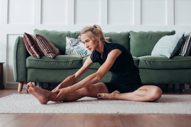 istock Fit woman stretching at home Forward bend. 1371912978
