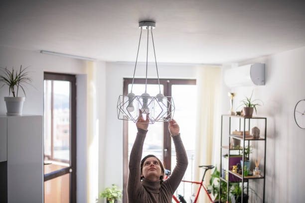 istock Woman changing light bulb in living room. 1371913192