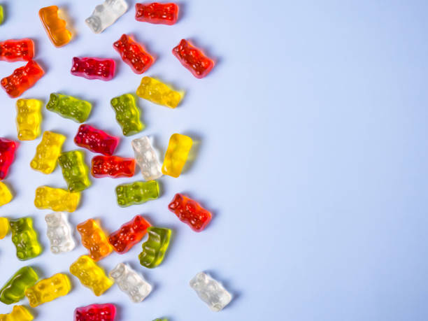 istock Delicious bright gummy bears on a blue background, flat lay 1371916052