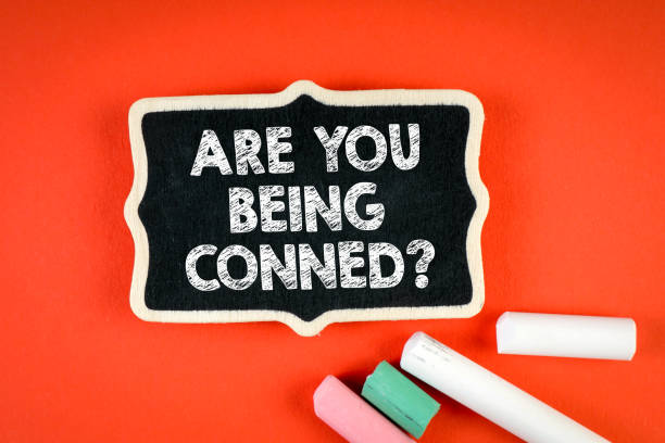 istock Are You Being Conned. Miniature chalk board with chalk pieces on red background 1371916541