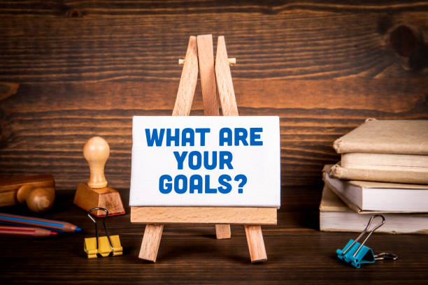 istock What are your goals? Text on a miniature easel. Dark textured background 1371917453