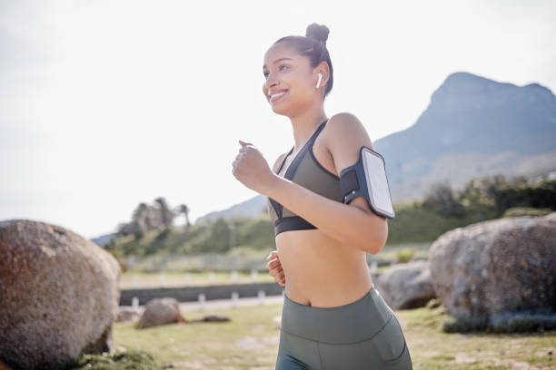 公園で走りに行くフィット感のある若い女性のショット - arm band ストックフォトと画像