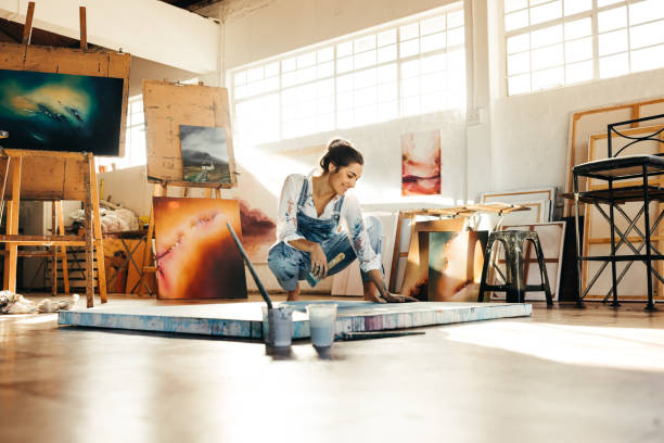 istock Cheerful artist working on a new painting in her studio 1371919061