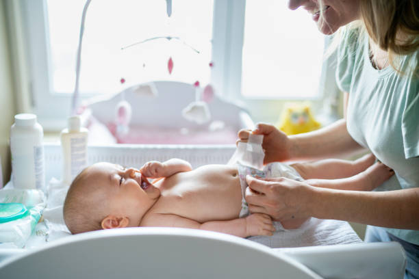 Baby in bedroom getting diaper changed stock photo