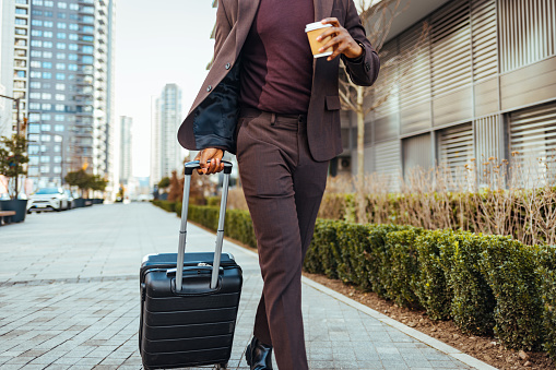 Shot of a businessman walking around town with his luggage