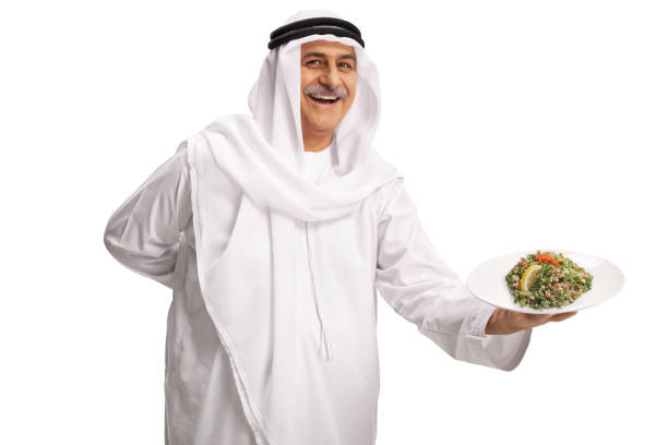 istock Mature arab man holding a plate with arabic salad tabule and smiling 1371920607
