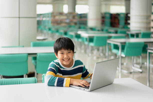 istock Portrait of Cute Asian boy studying or playing game with laptop computer 1371922062