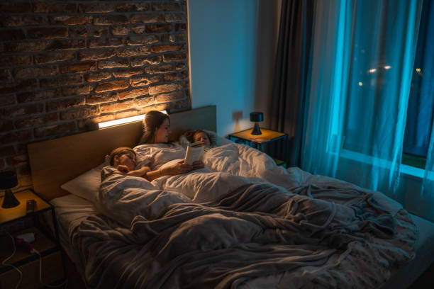 istock Mother lying in bed with her kids and reading bedtime stories 1371925521
