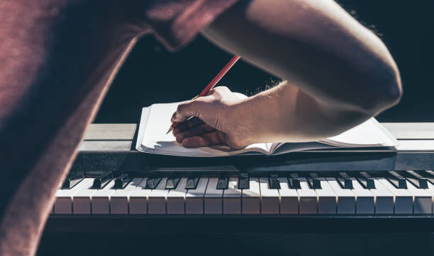 istock A man plays the piano and writes in a notebook in the dark. 1371927043